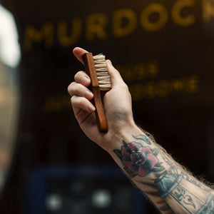 Redchurch Beard Brush held by a barber outside of our store