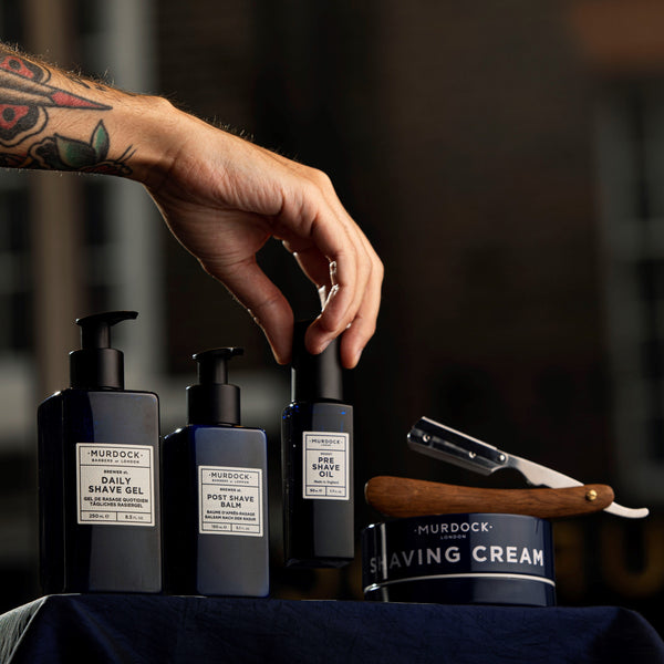 Murdock London Shave range on a shelf with a barbers hand